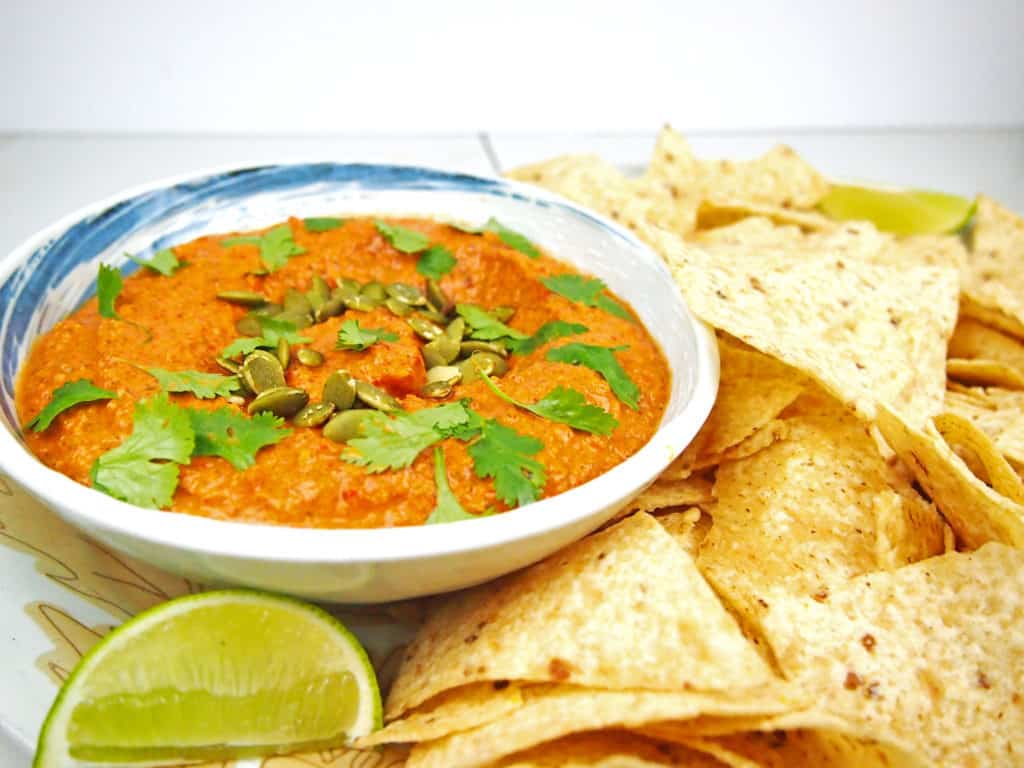 Bowl of red pepper and peptita salsa with chips.