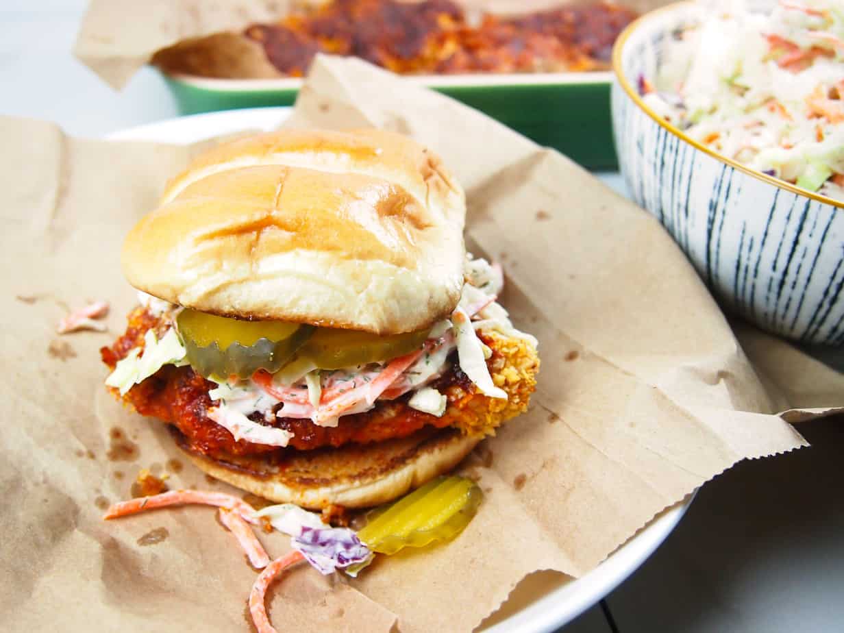 Hot, spicy chicken on a sandwich bun with pickles and dill slaw. 
