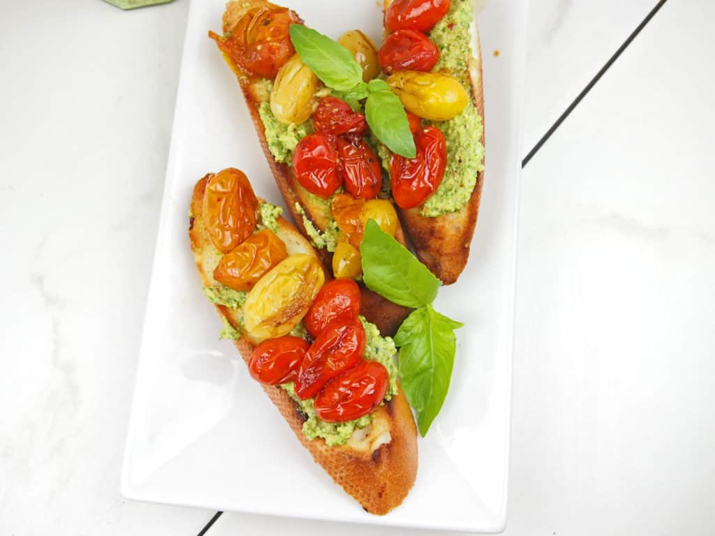 Tomato bruschetta with pesto and basil on a plate