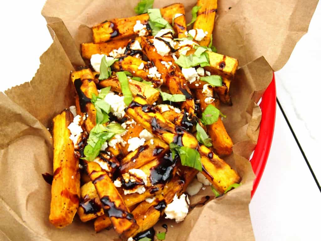 close-up of loaded Greek fries with feta, basil, and balsamic glaze