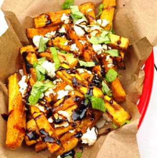 close-up of loaded Greek fries with feta, basil, and balsamic glaze