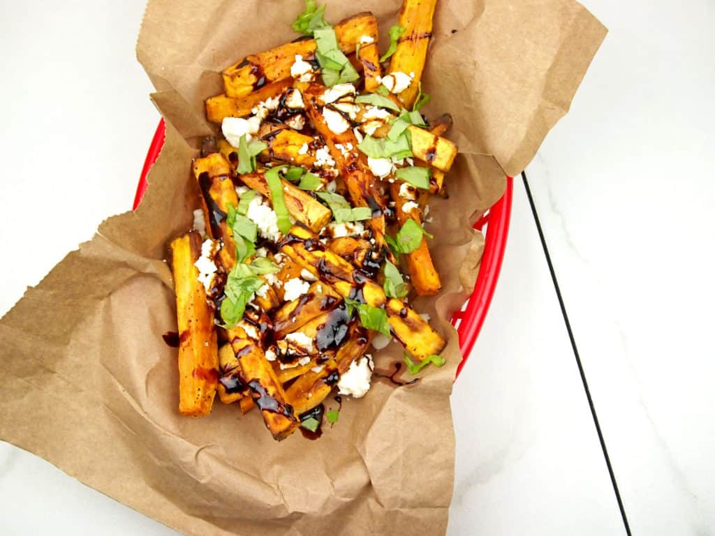 overhead view of loaded Greek fries with feta, basil, and balsamic glaze