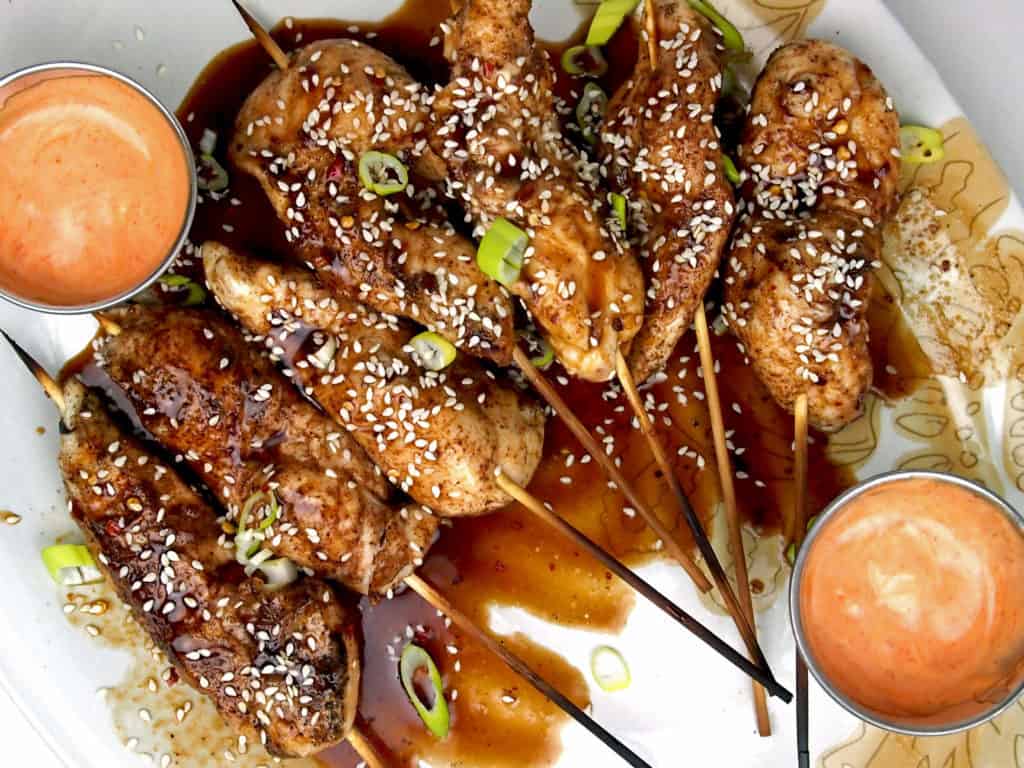 Chicken skewers on a platter with honey hoisin sauce and sriracha mayo for dipping