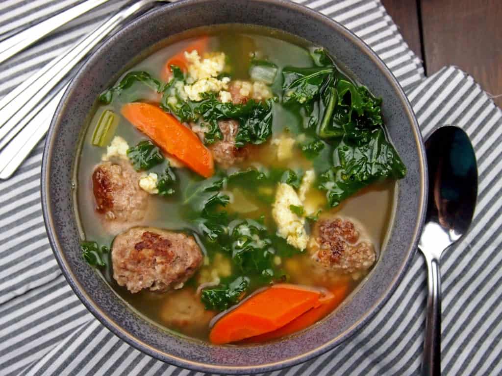 Italian wedding soup with meatballs, carrots, onions, and kale