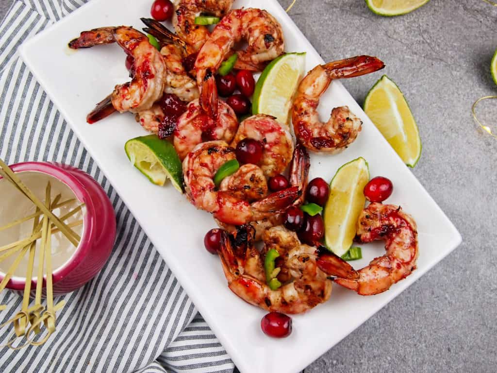 Overview of platter of cranberry marinated shrimp with limes