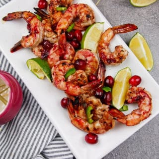 Overview of platter of cranberry marinated shrimp with limes