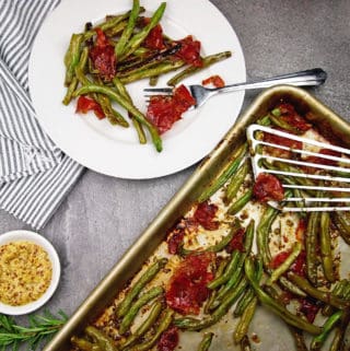 overview of a plate and sheet pan of crispy green beans, prosciutto, and mustard vinaigrette