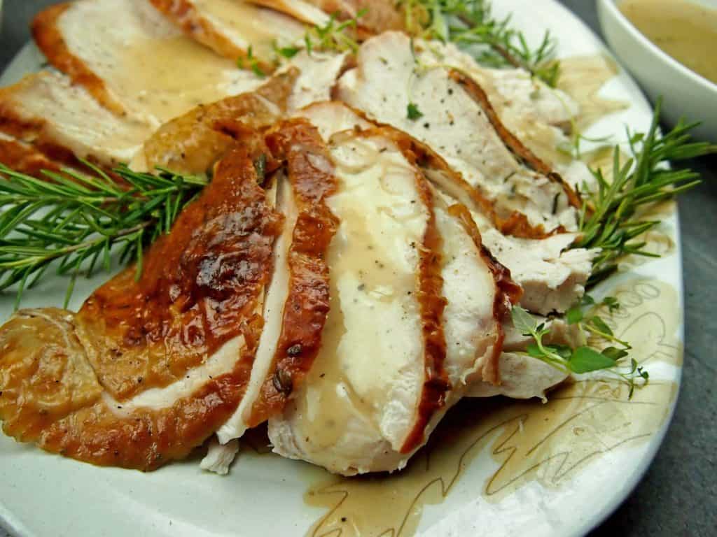 Close up of roasted turkey breast with herbs on a platter