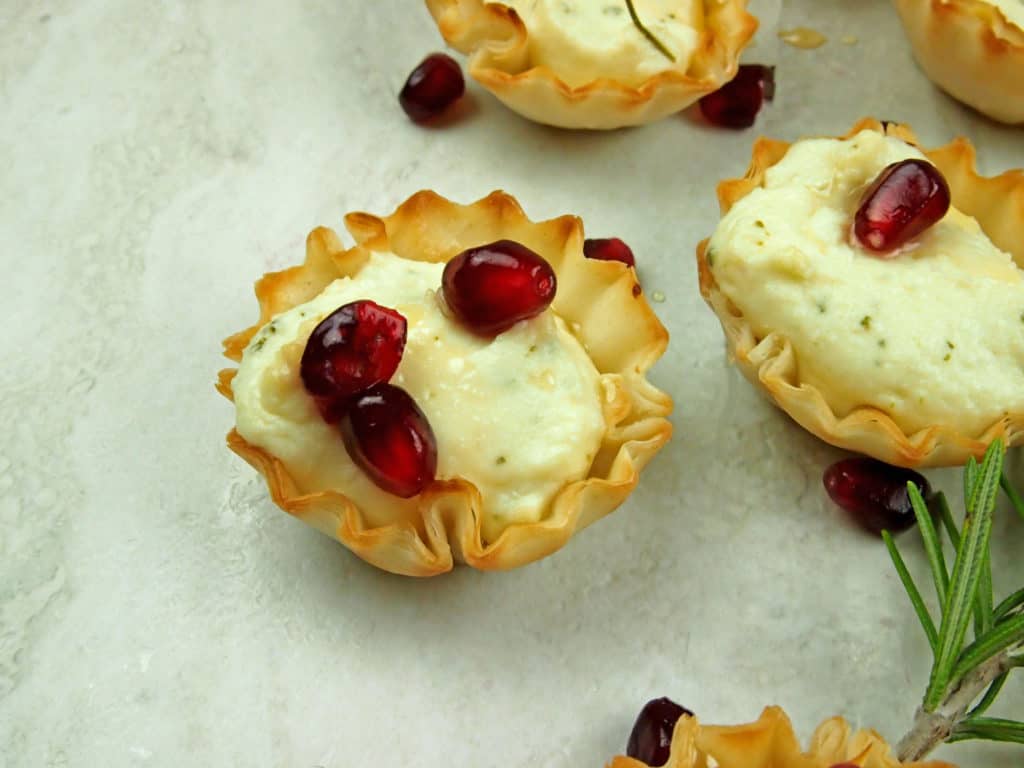 Close up of whipped feta in phyllo cups with pomegranate seeds