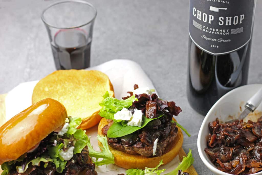 Burgers with onion, red wine, and bacon jam with spring mix and goat cheese and a bottle of Cabernet