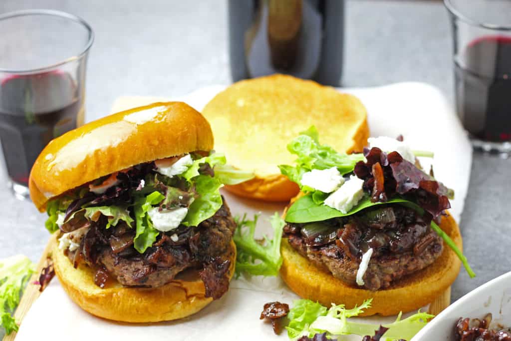 Burgers with onion, red wine, and bacon jam with spring mix and goat cheese