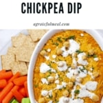 Buffalo chickpea dip surrounded by veggies and crackers on a plate.