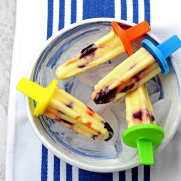 Cherry Mango Popsicles laid out in a bowl of ice.