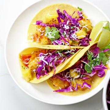 Overview of air fryer coconut shrimp tacos with honey-lime slaw on a white background.