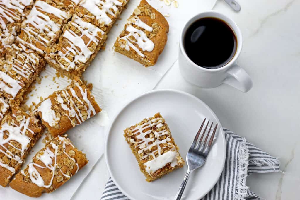 Sliced vegan coffee cake on a white background with a cup of coffee