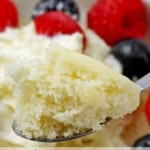 Close up of a bite of the vanilla mug cake with the cake in the background with the words "microwave vanilla mug cake. Done in 60 seconds!"