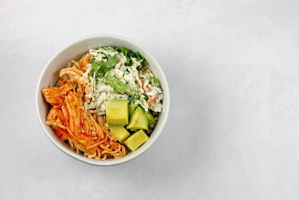 Overhead view of the buffalo chicken rice bowl on a white background.