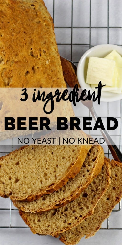A loaf of 3 ingredient bread sliced on a cooling rack with a blue and white napkin, butter knife, and a little bowl of butter on the side on a white background. The photo has text overlay that says "3 ingredient beer bread, no yeast, no knead"