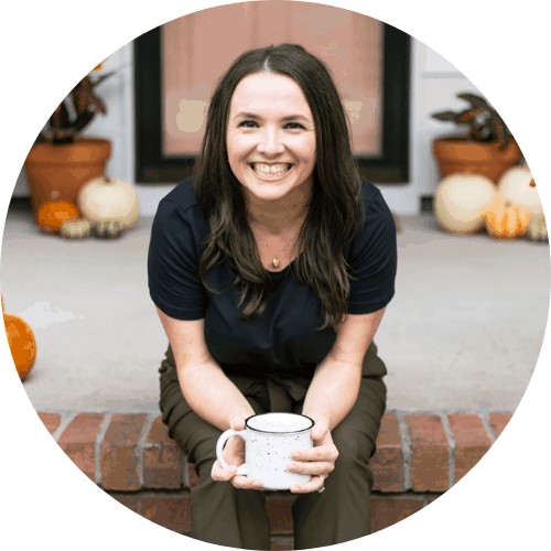 Photo of Melissa sitting on porch with coffee cup leaning forward with pumpkins and plants on the porch.