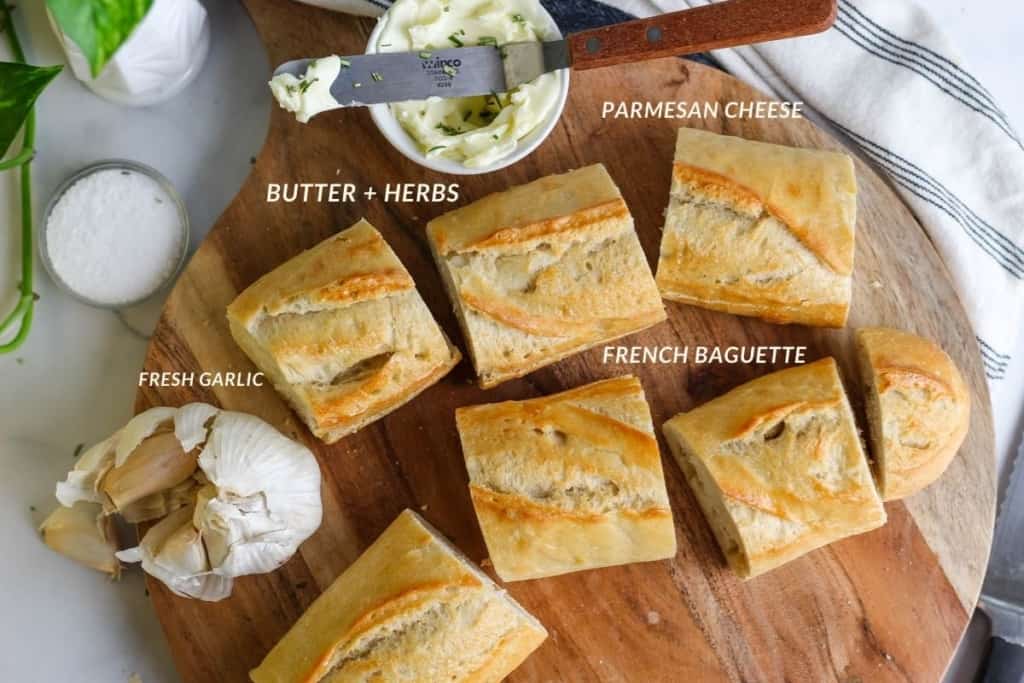 Slices of French baguette, fresh garlic, butter, herbs, and parmesan cheese with text labels noting each ingredient.