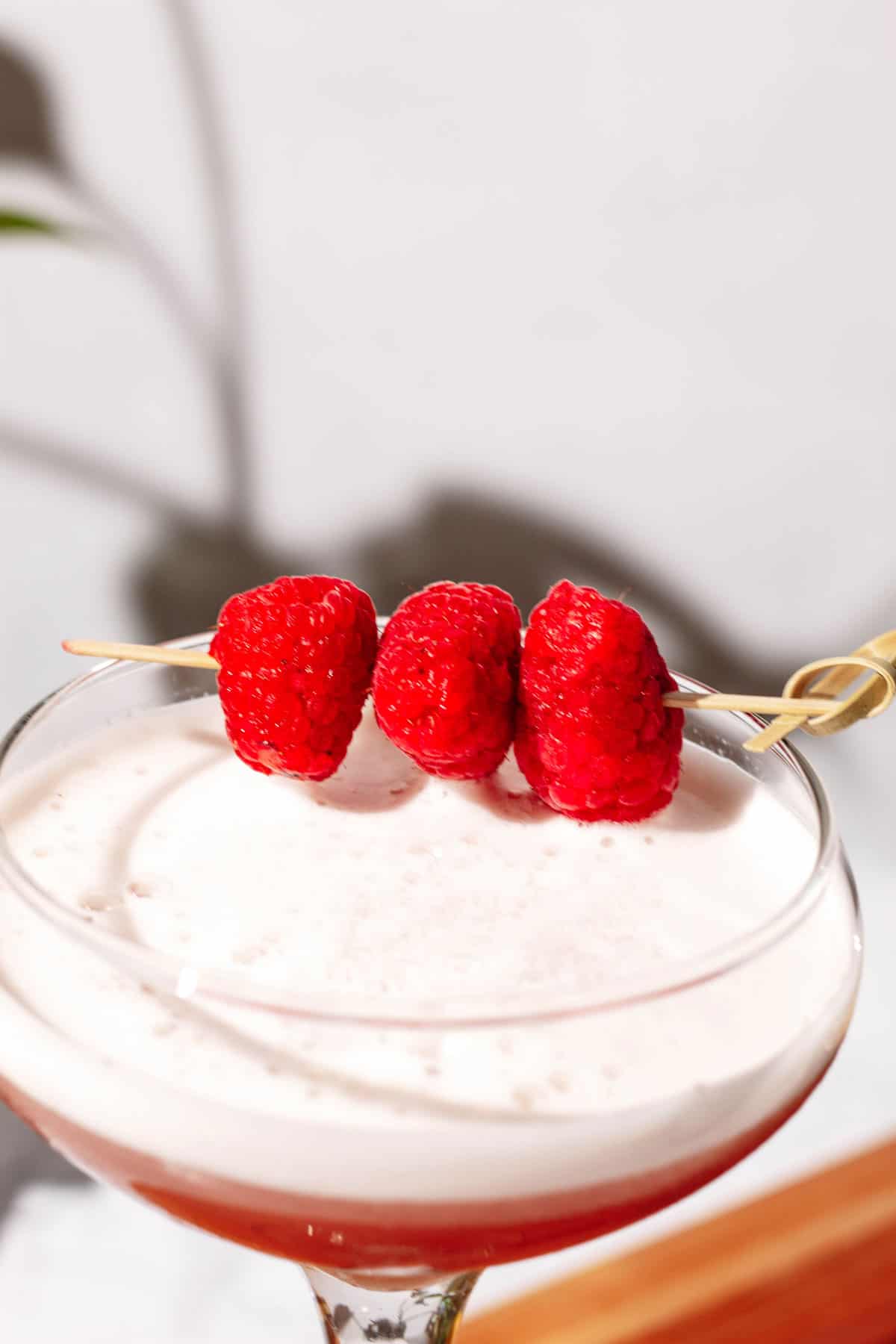 Close up of the white foam and fresh raspberry garnish on top.