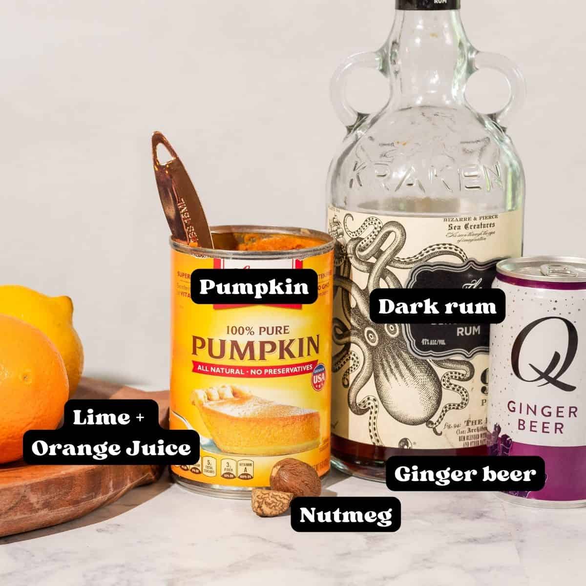 Ingredients for fall rum cocktail on a white countertop labeled in black and white lettering that says "lime and orange juice, pumpkin, nutmeg, ginger beer, dark rum"