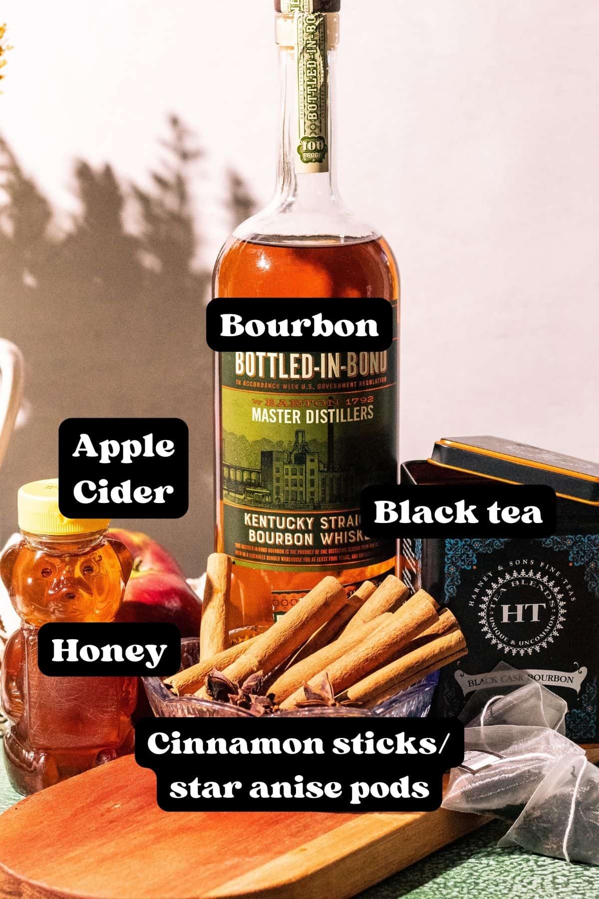 Labeled photo of bourbon, apple cider, honey, cinnamon sticks, and black tea.