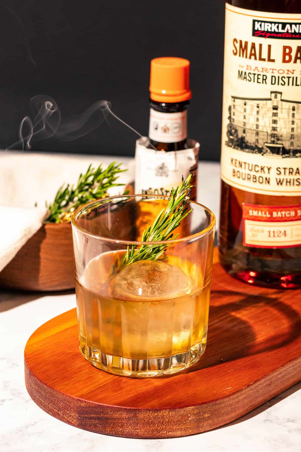 Old fashioned with a smoking sprig of rosemary as a garnish.