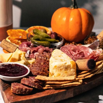 Charcuterie board with a pumpkin in the background.