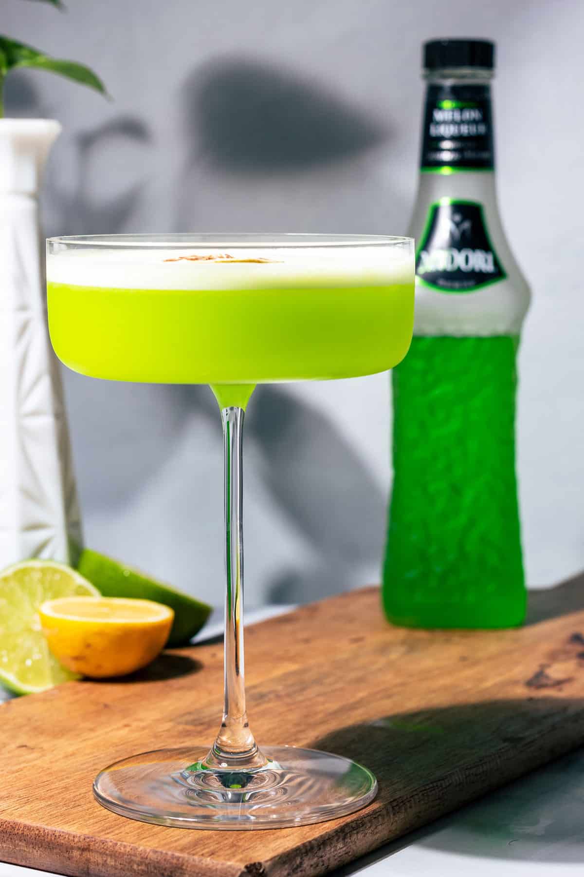 Midori sour in a large coupe glass.