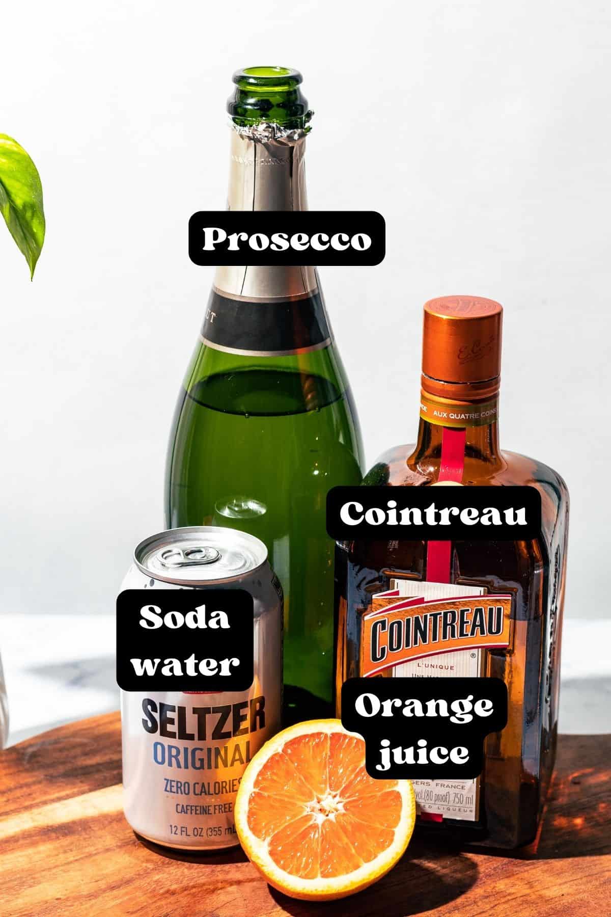 Ingredients for the cocktail spread out on a wood surface.