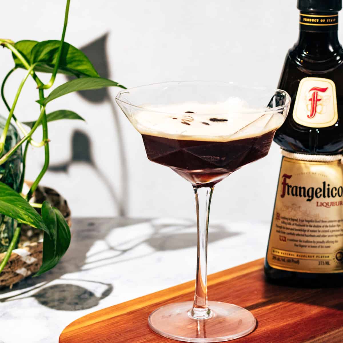 Espresso martini with a bottle of Frangelico in the background.