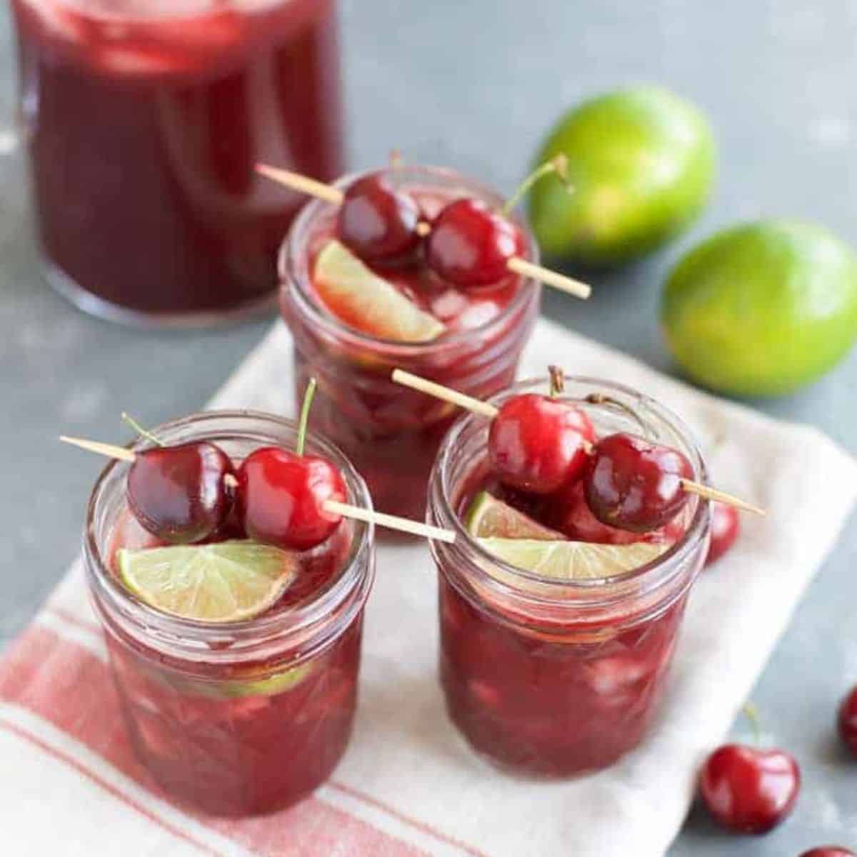 3 cherry margaritas on a kitchen towel.