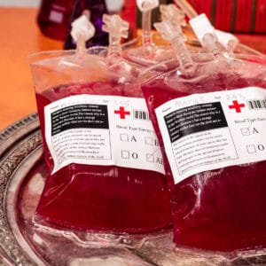 Filled blood bag cocktails on a tarnished silver platter.