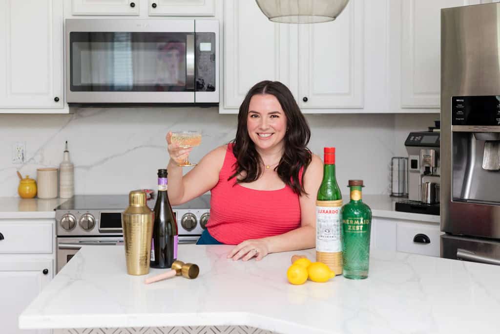 Melissa raising a cocktail glass for a toast.