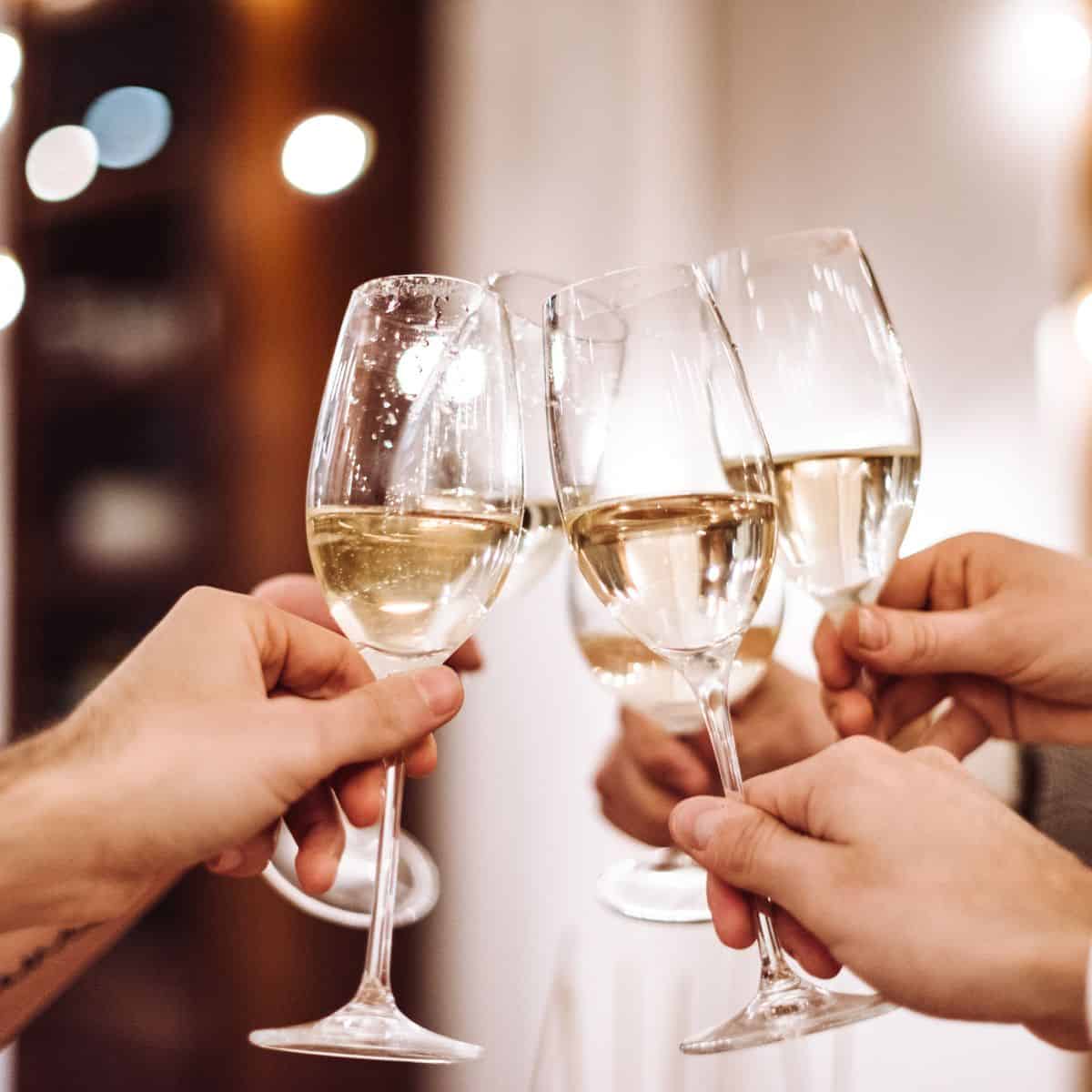 Three champagne flutes being clinked together.