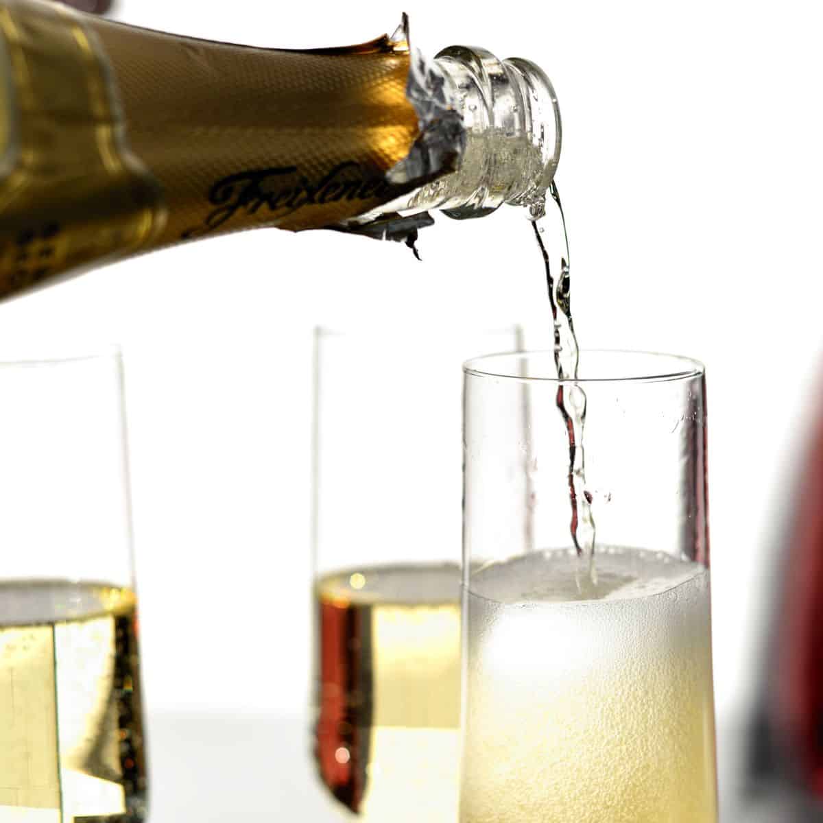 Sparkling wine being poured into a champagne flute.