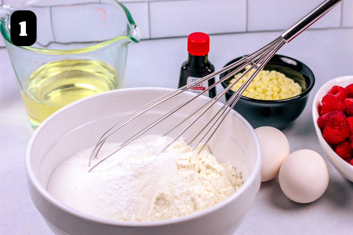 Dry ingredients in a white bowl with a whisk.