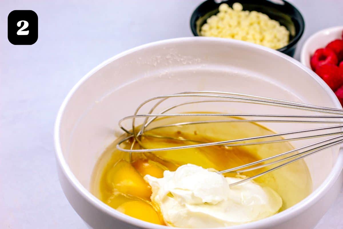 Wet ingredients in a bowl with a whisk.