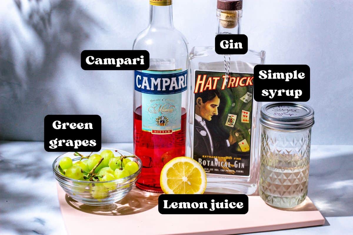 Ingredients for the cocktail on a pink surface.