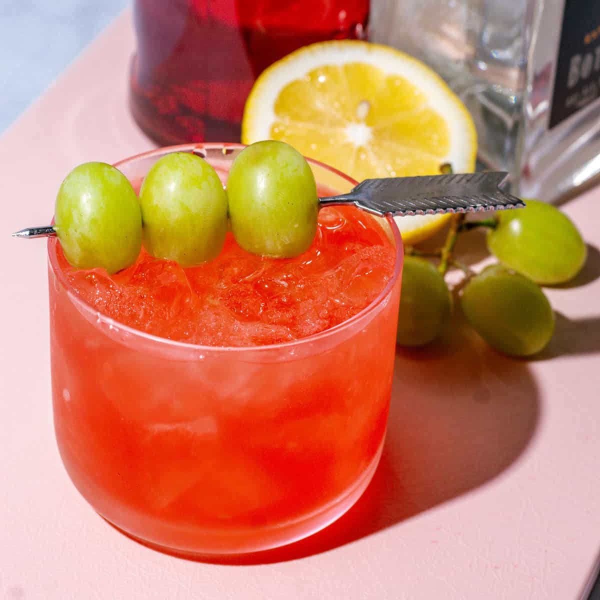 Cocktail garnished with a skewer of green grapes.